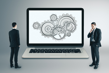 Businessmen with cogwheels on laptop screen. Teamwork and engineering cocnept. 3D Renderingの写真素材