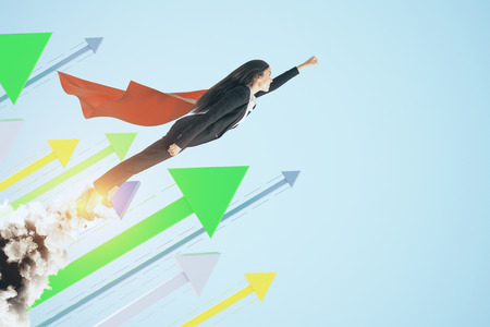 Super woman launching on creative blue background with arrows. Leadership and financial growth conceptの写真素材
