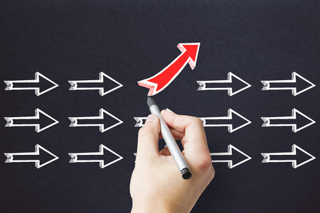 Hand drawing different arrows on concrete background. Leadership and creativity conceptの写真素材