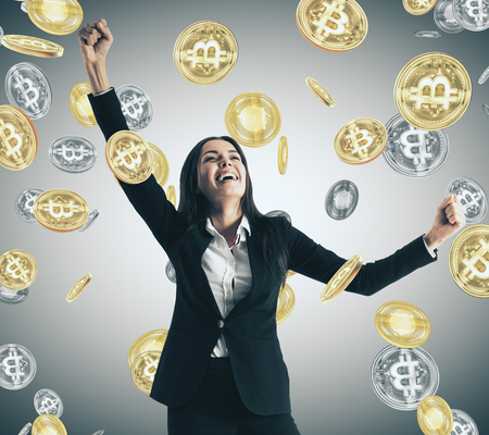 Happy businesswoman with creative bitcoin rain. Lottery and cryptocurrency conceptの写真素材