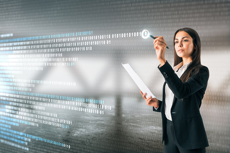 Attractive young european businesswoman writing binary code on abstract blurry interior background. Computing, engineering and software concept. Double exposureの写真素材