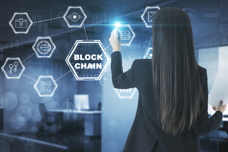 Businesswoman with creative digital blockchain interface in blurry office interior. Future and trade concept. Double exposureの写真素材