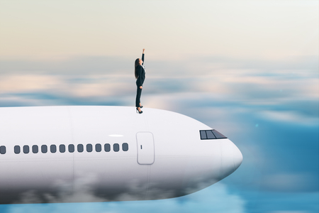 Superhero businesswoman with airplane on sky background. Confidence and protection concept.の写真素材