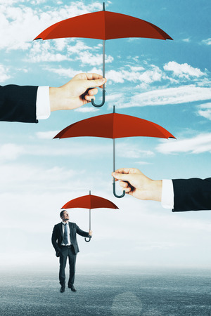 Abstract image of businessman with several umbrellas. Security and finance conceptの写真素材