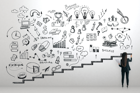 Young businesswoman with business sketch on concrete background. Career development and growth conceptの写真素材