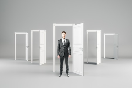 Businessman in abstract interior with open doors. Opportunity and future concept.の写真素材