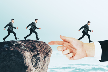 Businessmen running to hand from cliff. Teamwork and risk conceptの写真素材