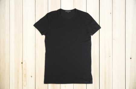 Blank black shirt on wooden background. Fabric and fashion concept. Mock upの写真素材