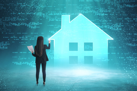 Young european businesswoman with digital house icon. Smart home and security concept.の写真素材