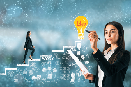 Young businesswoman with business sketch on blurry background. Management and innovation conceptの写真素材