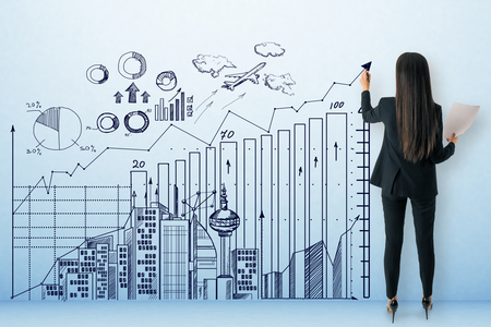Young businesswoman with business sketch on concrete background. Career development and finance conceptの写真素材