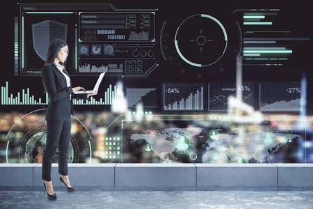 Attractive young european businesswoman using laptop on rooftop with digital business interface and night city view. Future and network concept. Double exposureの写真素材