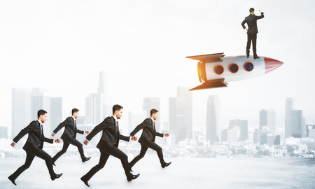Businessmen following leader on rocket on city background. Leadership and entrepreneur conceptの写真素材