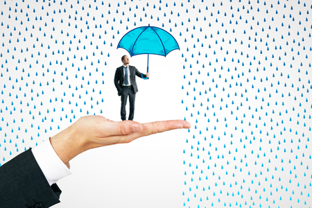 Hand holding businessman with drawn umbrella on white rain background. Protection and safety conceptの写真素材