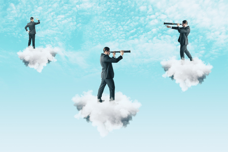 Businessmen on cloud looking into the distance with binoculars on sky background. Teamwork, vision and job search conceptの写真素材