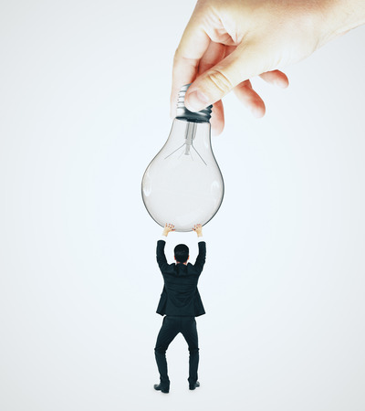 Businessman holding lamp on white background. Idea and innovation conceptの写真素材