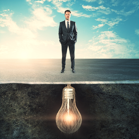 Businessman with lamp roots standing on sky background. Career and innovation conceptの写真素材
