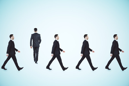 Rows of businessmen walking on light background. Teamwork and cooperation conceptの写真素材