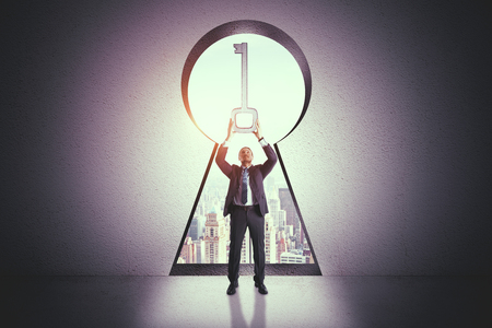 Businessman with abstract key hole on city background. Access and success conceptの写真素材