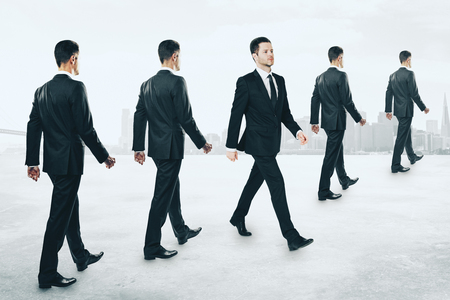 Rows of businessmen walking on light background. Teamwork and success conceptの写真素材