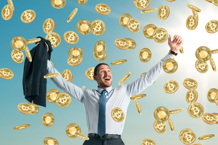 Businessman celebrating golden bitcoin rain on sky background. Cryptocurrency and success conceptの写真素材