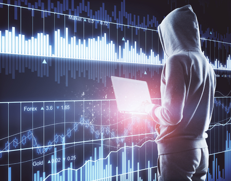 Young hacker using laptop with digital forex chart. Investment and crime concept. Double exposureの写真素材
