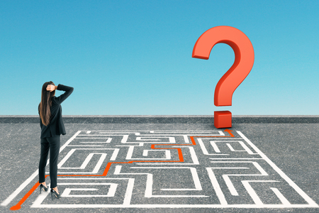 Businesswoman with maze and question mark on blue background. Challenge and doubt conceptの写真素材