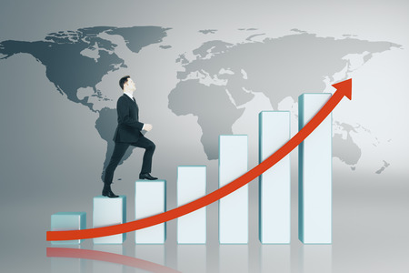 Businessman climbing abstract digital business chart interface with map. Global business, finance and growth concept.の写真素材