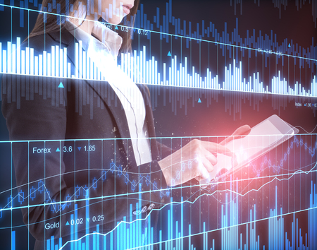 Investment and trade concept. Attractive young businesswoman using tablet with forex chart. Double exposureの写真素材