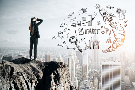 Back view of young businesswoman looking at business sketch from cliff. New York city background. Startup and finance conceptの写真素材