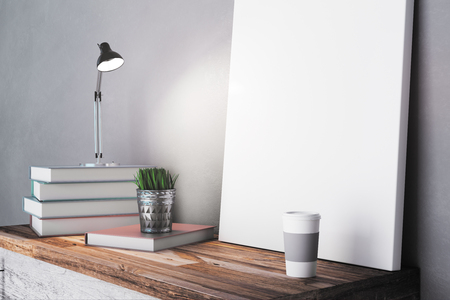 Close up of empty poster on table with book stack, lamp, decorative plant and coffee cup. Design concept. Mock up, 3D Renderingの写真素材