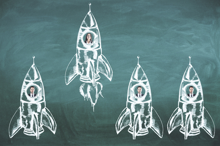 Creative rocket sketch with businesspeople on chalkboard wall background. Start up and teamwork conceptの写真素材
