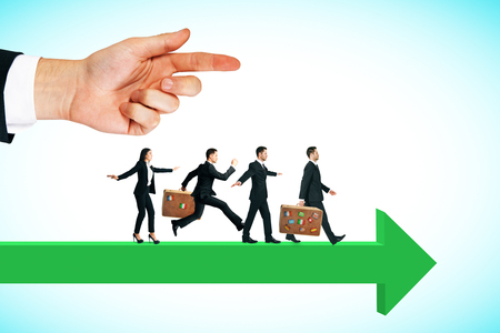 Side view of hand pointing at young businesspeople running on green  arrow. Sky background. Competition and challenge conceptの写真素材