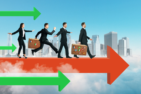 Side view of young businesspeople running on red arrow. Sky and city background. Teamwork and competition conceptの写真素材