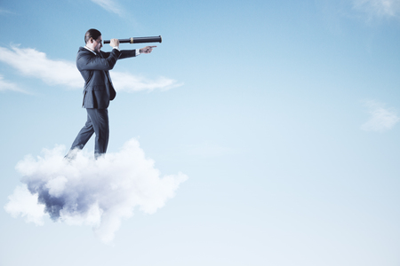 Businessman on cloud looking into the distance with telescope. Vision and research conceptの写真素材
