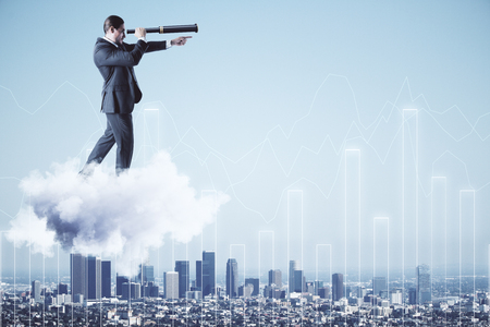 Businessman on cloud and city background with glowing chart looking into the distance with telescope. Vision and finance conceptの写真素材