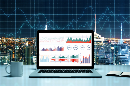 Trade and finance concept. Laptop, coffee cup and supplies on illuminated night New York city background with forex chart. 3D Renderingの写真素材