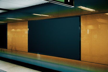 Side view of empty black subway poster on orange wall. Advertisement and urban concept. Mock upの写真素材