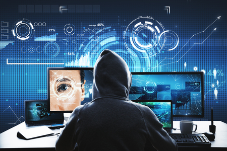 Hacker at desk using computer with glowing interface. Phishing, Face ID and access conceptの写真素材
