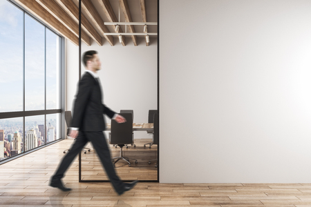 Side view of young business man walking in modern meeting room interior with copy space. Mock up,の写真素材