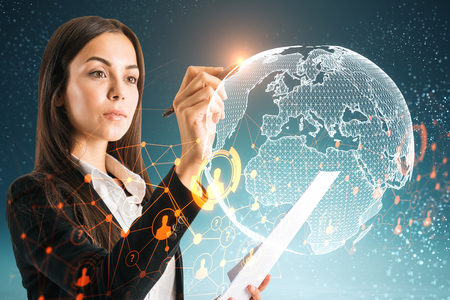 Side view of attractive young european businesswoman using abstract globe interface om blurry background. Network and science conceptの写真素材