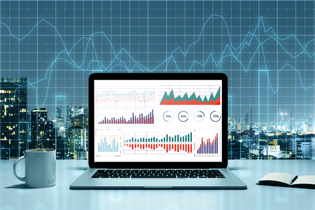 Trade and currency exchange concept. Laptop, coffee cup and supplies on illuminated night New York city background with forex chart. 3D Renderingの写真素材
