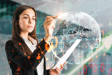 Side view of attractive young european businesswoman using abstract globe interface om blurry background. Network and forex trade conceptの写真素材