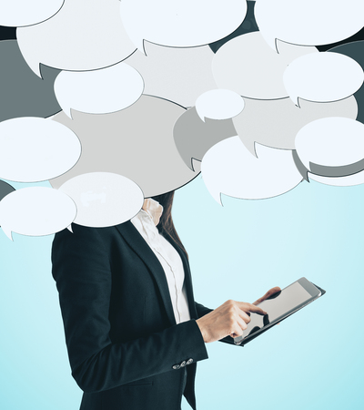 Unrecognizable businesswoman using tablet with abstract speech bubbles. Communication conceptの写真素材