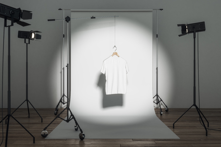 Empty white tee in photo studio with professional lighting equipment. Fashion, design and mockup concept. 3D Renderingの写真素材
