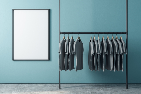 Hanger with row of tshirts in interior with empty poster on blue wall. Design, fashion and ad concept. Mock up, 3D Renderingの写真素材