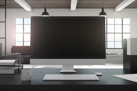 Designer desktop with empty black computer screen in modern office interior. Design and ad concept. Mock up, 3D Renderingの写真素材