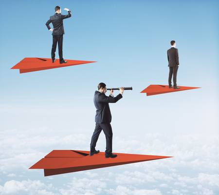 Businessmen on red paper planes looking into the distance with telescopes on sky background. Vision and research conceptの写真素材