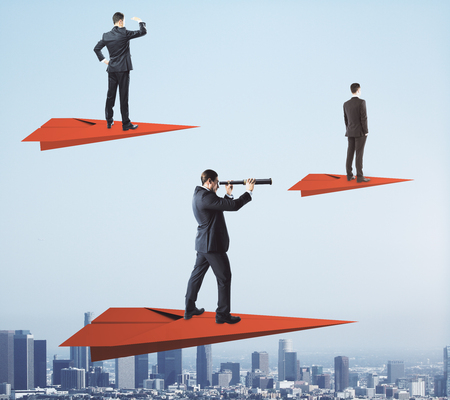 Businessmen on red paper planes looking into the distance with telescopes on sky background. Vision and job search conceptの写真素材