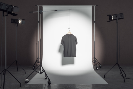 Empty black tee in photo studio with professional lighting equipment. Fashion, design and mockup concept. 3D Renderingの写真素材